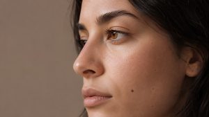 Close-up three-quarter profile of a woman with a natural facial silhouette, highlighting the nose under soft studio lighting, representing rhinoplasty in Miami consultation and aesthetic results